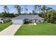 Inviting single-story home with a lush green lawn, long driveway, and an attached two-car garage at 4501 Sw 159Th Street Rd, Ocala, FL 34473