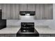 Modern kitchen features black stove and grey cabinets with countertop at 4501 Sw 159Th Street Rd, Ocala, FL 34473