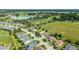 Aerial view of a residential area with a golf course, a lake, and mature trees at 5093 Nw 35Th Lane Rd, Ocala, FL 34482