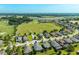 Aerial view of a neighborhood with houses surrounding a lush golf course and scattered trees at 5093 Nw 35Th Lane Rd, Ocala, FL 34482