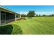 Spacious backyard with lush lawn and landscaping around screened-in lanai at 5093 Nw 35Th Lane Rd, Ocala, FL 34482