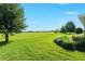 Green backyard featuring a large lawn, mature trees and meticulously maintained landscaping at 5093 Nw 35Th Lane Rd, Ocala, FL 34482