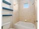 Bright bathroom featuring tiled shower/tub and integrated shelving for storage at 5093 Nw 35Th Lane Rd, Ocala, FL 34482