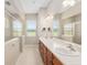 Bathroom with double vanity sinks, large mirror, tiled floor and glass shower with a view at 5093 Nw 35Th Lane Rd, Ocala, FL 34482