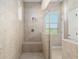 Spacious tiled shower boasts glass enclosure, bench seat, and a window with a view at 5093 Nw 35Th Lane Rd, Ocala, FL 34482