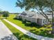 Exterior side view of a grey home featuring solar panels, lush landscaping, and a sidewalk at 5093 Nw 35Th Lane Rd, Ocala, FL 34482