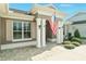 Close up front entrance with decorative columns, shutters, and an American flag at 5093 Nw 35Th Lane Rd, Ocala, FL 34482