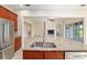 Granite kitchen island with sink and dishwasher overlooking fireplace and living area at 5093 Nw 35Th Lane Rd, Ocala, FL 34482