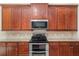 Kitchen area showcasing wood cabinets, granite countertops, and stainless steel appliances at 5093 Nw 35Th Lane Rd, Ocala, FL 34482