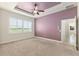 Spacious main bedroom with a tray ceiling, large window with plantation shutters, and carpet at 5093 Nw 35Th Lane Rd, Ocala, FL 34482