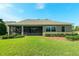 Rear exterior featuring lanai, lush greenery and manicured landscaping at 5093 Nw 35Th Lane Rd, Ocala, FL 34482