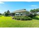 Back exterior with lawn and greenery surrounding stucco home at 5093 Nw 35Th Lane Rd, Ocala, FL 34482