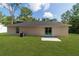 Spacious backyard with sliding glass doors, a concrete patio and lush green lawn at 5388 Nw 9Th St, Ocala, FL 34482