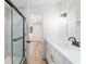 Modern bathroom featuring walk-in shower, white cabinets and countertops, and an oval mirror at 5388 Nw 9Th St, Ocala, FL 34482