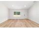 Clean and bright bedroom with wood floors, a white door, and a large window overlooking the yard at 5388 Nw 9Th St, Ocala, FL 34482