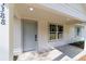 Close-up of the home's entrance with a gray front door, sidelight window, and covered porch at 5388 Nw 9Th St, Ocala, FL 34482