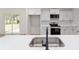 Modern kitchen with stainless steel appliances, white cabinets, and a sink overlooking the backyard at 5388 Nw 9Th St, Ocala, FL 34482