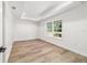Bright bedroom with tray ceiling, large window overlooking backyard, and wood-look flooring at 5400 Nw 9Th St, Ocala, FL 34482