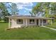 Charming home featuring a covered porch, green shutters, and manicured lawn at 5400 Nw 9Th St, Ocala, FL 34482