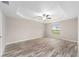 Spacious primary bedroom with tray ceiling, fan and wood-look flooring at 5908 Sw 111Th Place Rd, Ocala, FL 34476