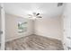 Light and bright bedroom with a ceiling fan, wood-look floors, and a large window at 5908 Sw 111Th Place Rd, Ocala, FL 34476