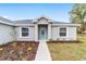Attractive home facade with light blue front door, complemented by new landscaping at 5908 Sw 111Th Place Rd, Ocala, FL 34476