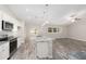 A wide kitchen featuring white cabinets, stainless steel appliances, and grey countertops at 5908 Sw 111Th Place Rd, Ocala, FL 34476