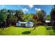 Charming cottage-style home with blue trim, lush lawn, and mature trees in a serene setting at 626 Ne 21St St, Ocala, FL 34470