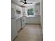 A functional kitchen featuring white cabinets and tile flooring at 6415 Ne 23Rd Ave, Ocala, FL 34479