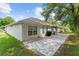 Back exterior of home featuring a spacious brick patio, perfect for outdoor dining and entertaining at 7242 Sw 115Th Pl, Ocala, FL 34476