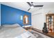 Bedroom showcasing a bed, bench, dark blue wall, and ceiling fan at 7242 Sw 115Th Pl, Ocala, FL 34476
