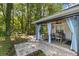 Inviting covered patio with dining area, ceiling fan, and scenic view of a lush, wooded backyard at 7242 Sw 115Th Pl, Ocala, FL 34476