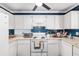 Bright kitchen with white cabinets, blue tile backsplash, and modern appliances at 7242 Sw 115Th Pl, Ocala, FL 34476