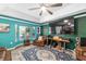 Cozy living room with large TV, ceiling fan, and bay window providing natural light at 7242 Sw 115Th Pl, Ocala, FL 34476