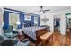 Relaxing bedroom features bold blue accent wall, ceiling fan, hardwood flooring and walk-in closet at 7242 Sw 115Th Pl, Ocala, FL 34476