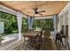 Inviting covered patio with dining area and ceiling fan overlooking a serene wooded backyard at 7242 Sw 115Th Pl, Ocala, FL 34476