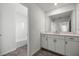 Bathroom with white cabinets, counter, a large mirror, and tub at 7695 Sw 64Th Street Rd, Ocala, FL 34474
