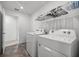 Well-lit laundry room featuring modern white washer and dryer units, and space for storage at 7695 Sw 64Th Street Rd, Ocala, FL 34474