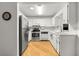Updated kitchen with wooden floors, white cabinetry and stainless steel appliances at 8850 Sw 97Th St # C, Ocala, FL 34481