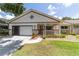 Charming single-story home with a cozy front porch, garage, and well-manicured landscaping at 8881 Sw 94Th St # E, Ocala, FL 34481