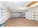 Spacious garage features patterned tile flooring, plenty of shelving and a ceiling fan at 8881 Sw 94Th St # E, Ocala, FL 34481