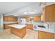 Bright kitchen features a center island, tile floors, wood cabinets and modern appliances at 8881 Sw 94Th St # E, Ocala, FL 34481