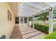 Covered patio featuring a pergola, tile floors, and manicured bushes at 8881 Sw 94Th St # E, Ocala, FL 34481