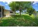 Spacious backyard featuring a beautiful tree, green grass, and a partial fence line at 8973 Sw 104Th Pl, Ocala, FL 34481