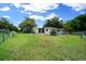 Spacious fenced backyard with home and trees under a blue sky at 8973 Sw 104Th Pl, Ocala, FL 34481