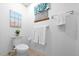 Neutral bathroom featuring tiled floors, a toilet, and a decorative ocean themed art print at 8973 Sw 104Th Pl, Ocala, FL 34481