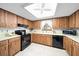 Charming kitchen with wood cabinetry, white countertops, and black appliances at 8973 Sw 104Th Pl, Ocala, FL 34481