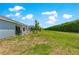 A spacious backyard with a privacy hedge and a patio area with a grill at 9209 Sw 58Th Cir, Ocala, FL 34476