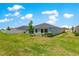 A spacious backyard and the rear exterior of the light blue home at 9209 Sw 58Th Cir, Ocala, FL 34476