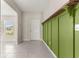 Bright foyer featuring sleek tile flooring, neutral walls, and decorative green wood paneling with rustic wooden shelf at 9209 Sw 58Th Cir, Ocala, FL 34476